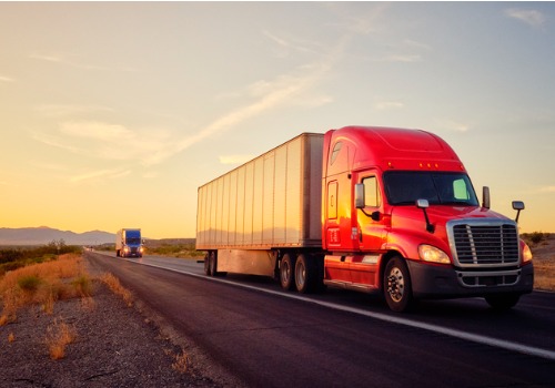 Trucks on the highway at sunset, during Truck Driver Jobs in Indiana