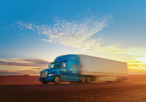 Trucking Jobs in Iowa as a trucker drives under a blue sky