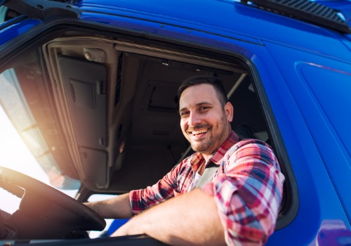 A happy driver leaning out his window while working Truck Driver Jobs in Missouri