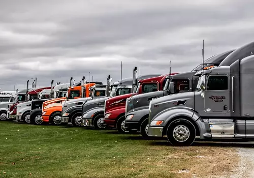 A line of Stoller Trucking trucks is seen. Stoller offers General Freight services.