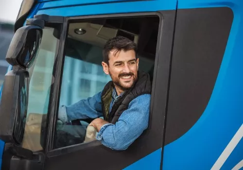 Happy truck driver representing Stoller Trucking's dry van and general freight services.