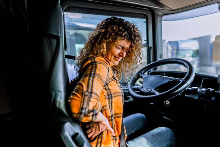 Female truck driver having back pain after working extra hours should follow these Tips for Lower Back Pain Relief on the Road